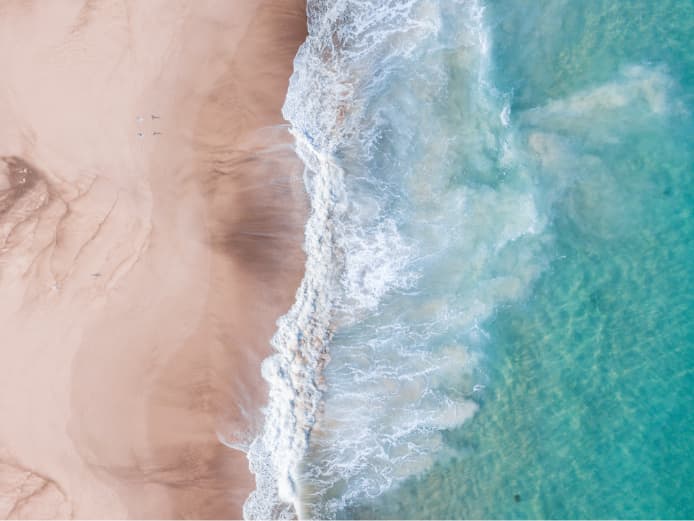 Waves rolling onto peach sands